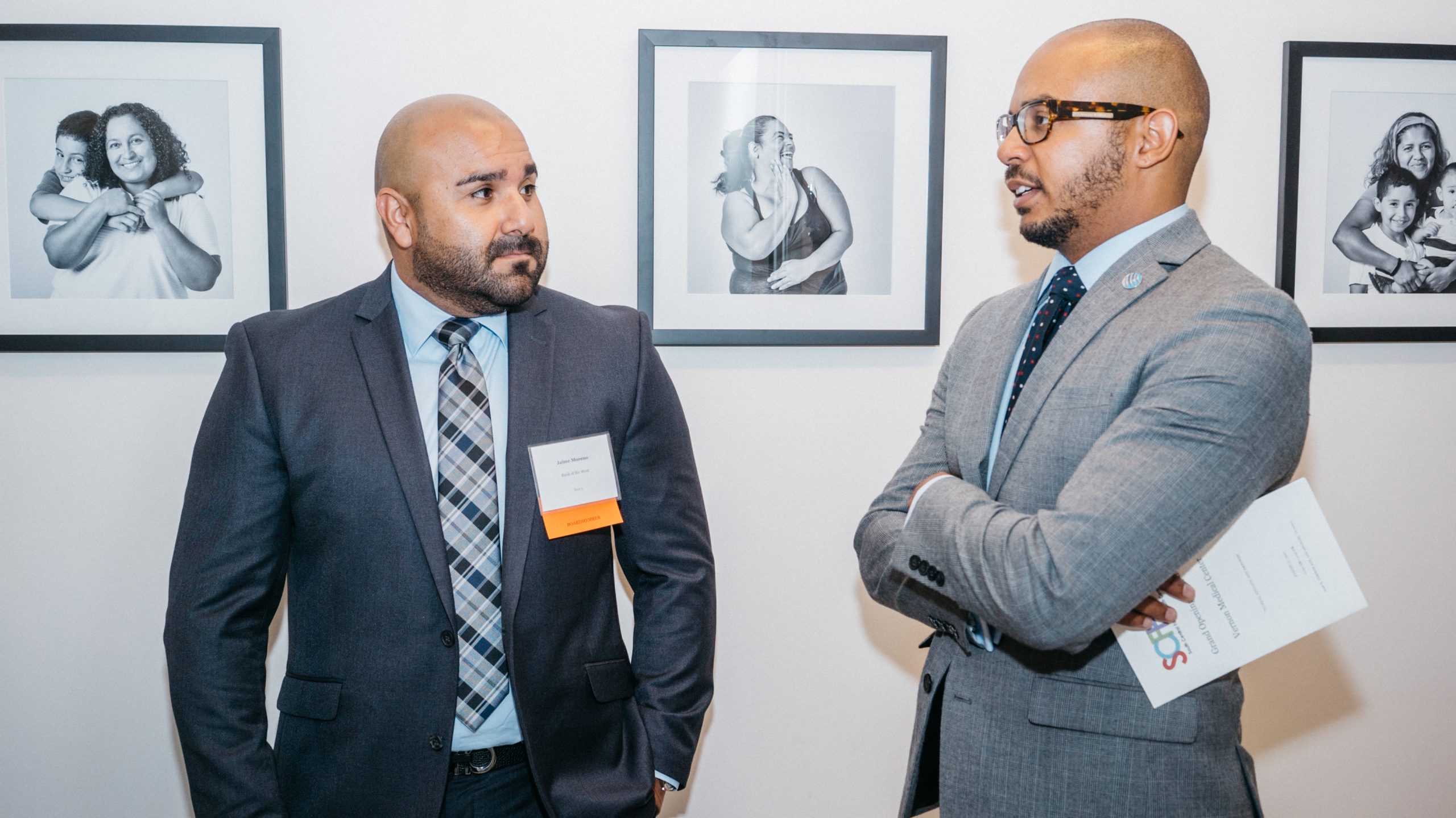 SCFHC Board Members Jaime Moreno and Amir Johnson. In front of photos taken for the NotUs Campaign to prevent cervical cancer.